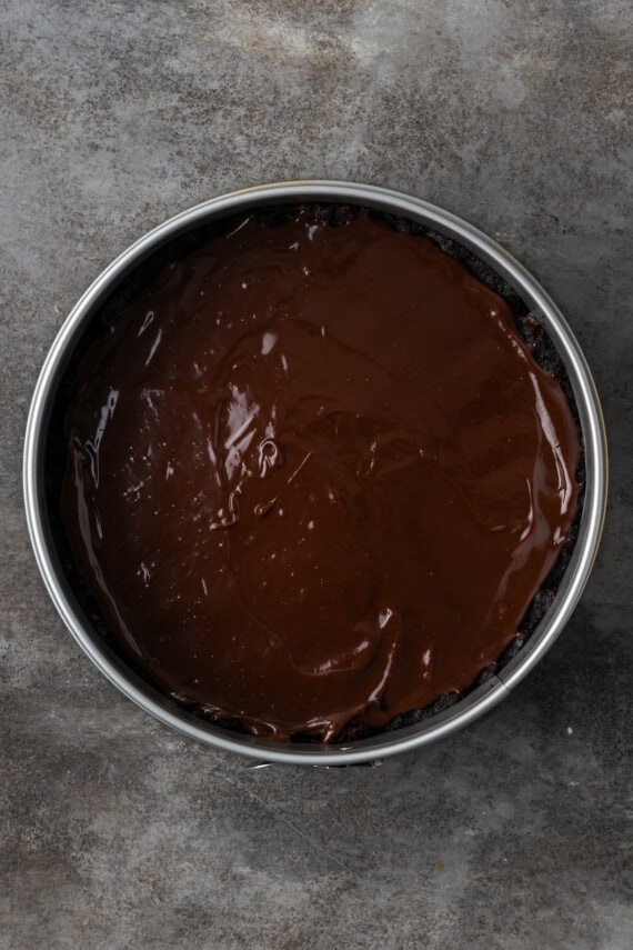 Der Brownie-Boden wird in einer Springform mit Karamellsauce überzogen.