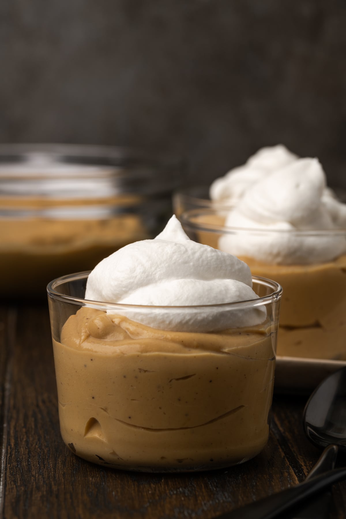 Bourbon-Butterscotch-Pudding wird in Gläsern serviert und mit Schlagsahne gekrönt.