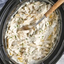 Topf mit Crock Pot Chicken Alfredo mit einem Löffel